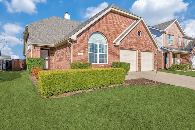 view of front of property featuring driveway, a chimney, fence, a front lawn, and brick siding