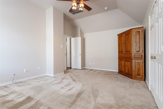 unfurnished bedroom featuring lofted ceiling, ceiling fan, baseboards, and light colored carpet