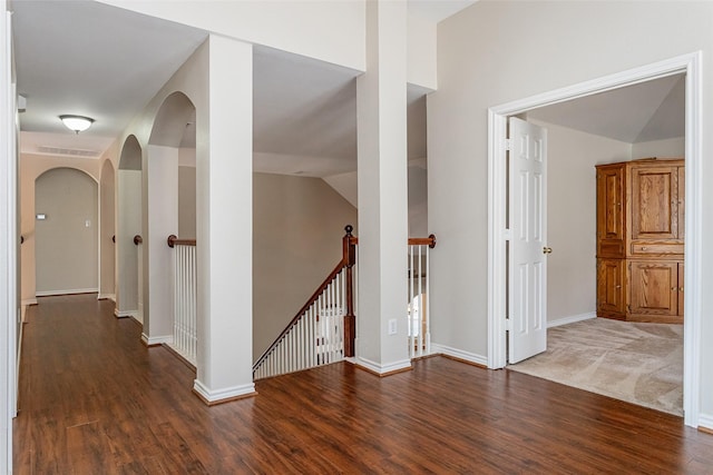 hall featuring baseboards, visible vents, an upstairs landing, and wood finished floors