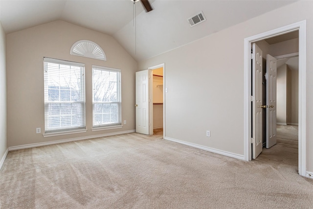 unfurnished bedroom featuring carpet floors, visible vents, vaulted ceiling, and baseboards