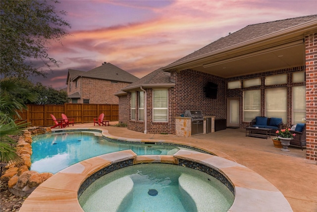 view of pool featuring an outdoor kitchen, area for grilling, a patio, fence, and a pool with connected hot tub