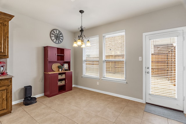 dining space with a chandelier, light tile patterned floors, baseboards, and a healthy amount of sunlight