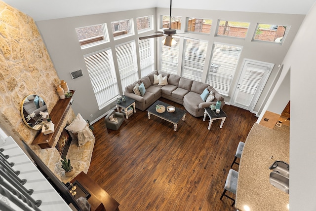 living room with baseboards, high vaulted ceiling, and dark wood-type flooring