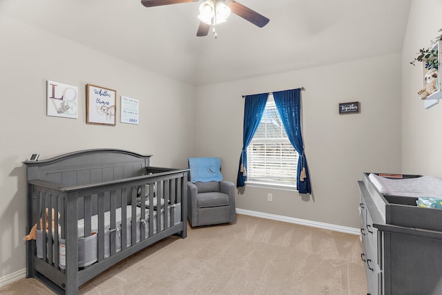 bedroom with baseboards, a ceiling fan, vaulted ceiling, carpet floors, and a nursery area