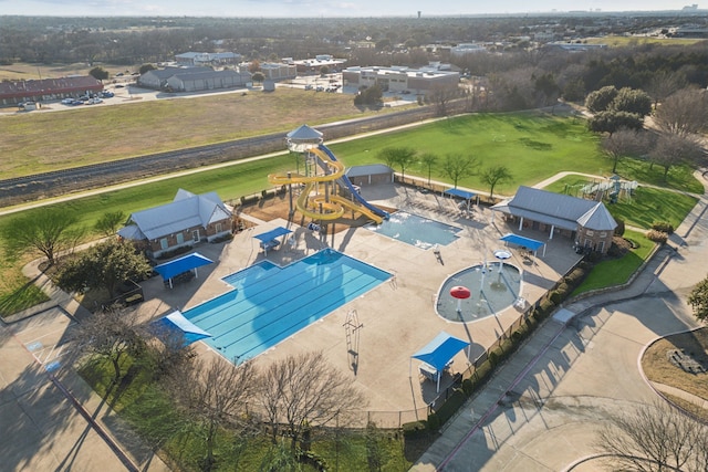 pool with a patio, a water slide, a water play area, and fence