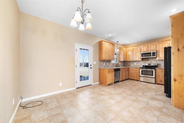 kitchen featuring stainless steel appliances, pendant lighting, backsplash, and baseboards