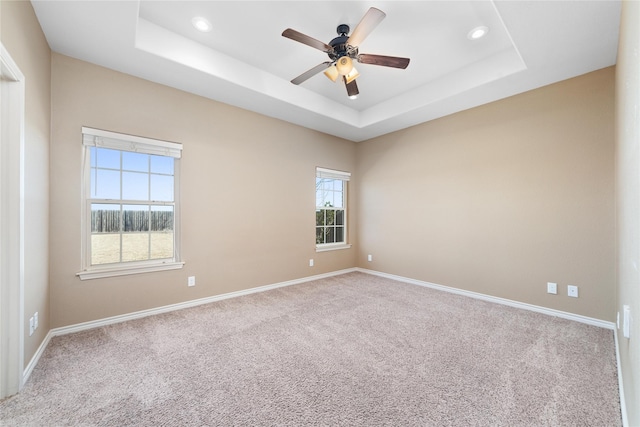 unfurnished room featuring carpet, baseboards, a raised ceiling, and recessed lighting