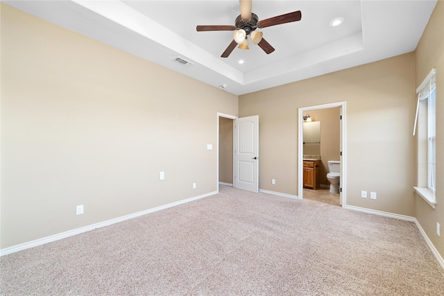 unfurnished bedroom with light carpet, baseboards, visible vents, a raised ceiling, and recessed lighting