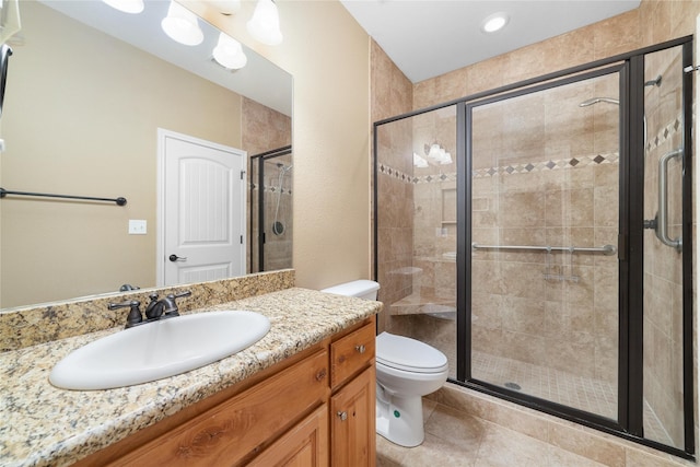 bathroom featuring vanity, a shower stall, toilet, and tile patterned floors