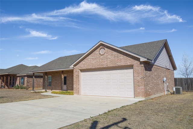 single story home featuring a garage, concrete driveway, brick siding, and fence