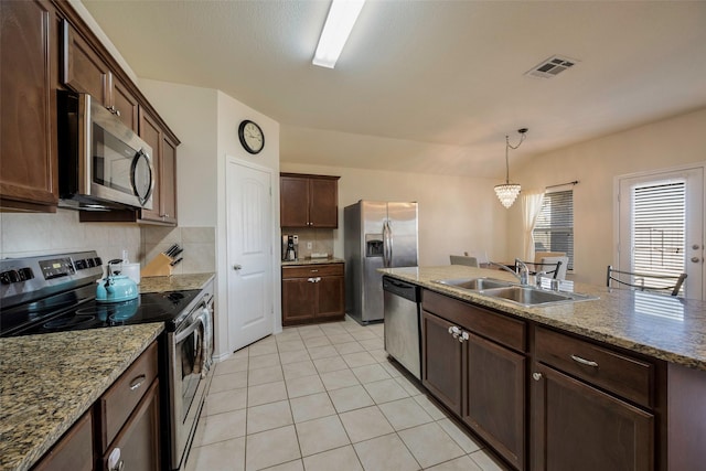 2278 Bryant Ln, Fate, TX 75189 - kitchen featuring stainless steel appliances, a sink, light tile patterned floors, pendant lighting, and dark brown cabinetry