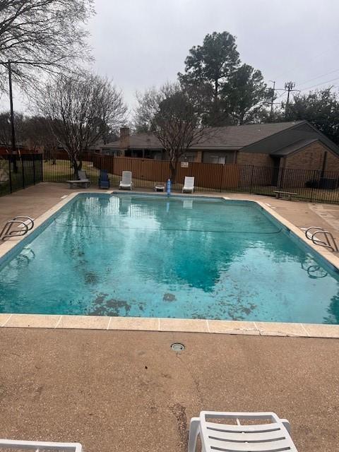 view of swimming pool with a patio, fence, and a fenced in pool