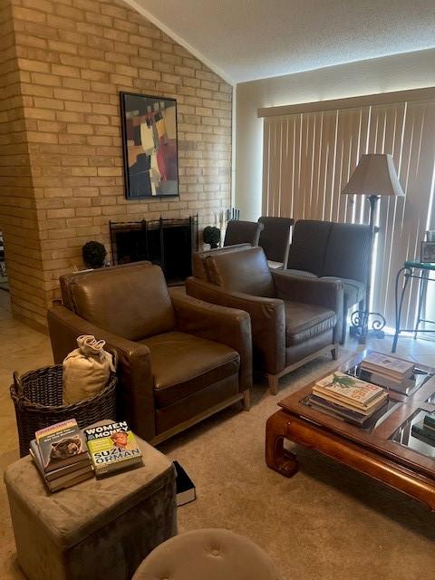 living area featuring vaulted ceiling and brick wall