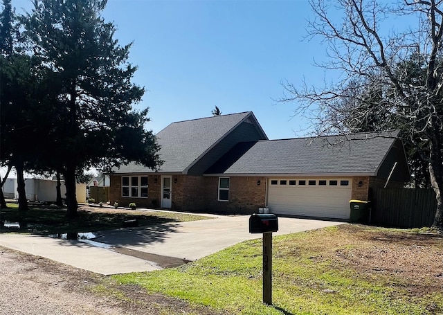 view of front of home featuring a garage, brick siding, driveway, and fence