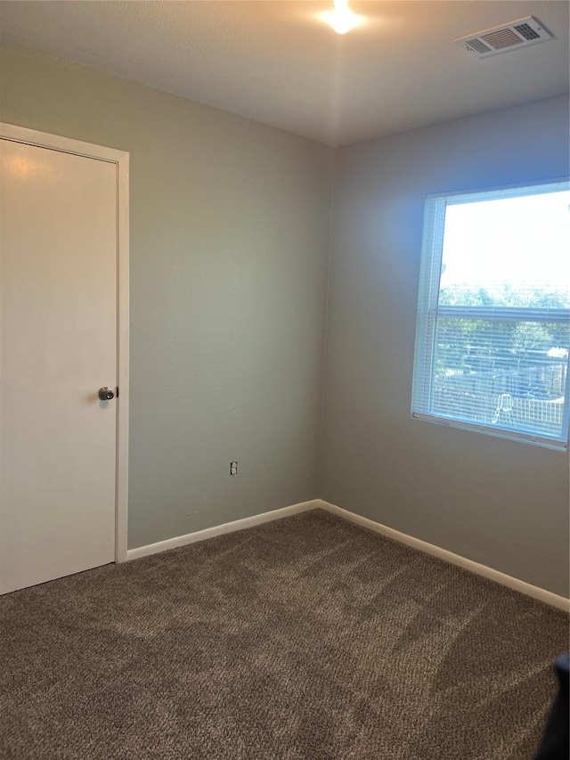 carpeted spare room with baseboards and visible vents