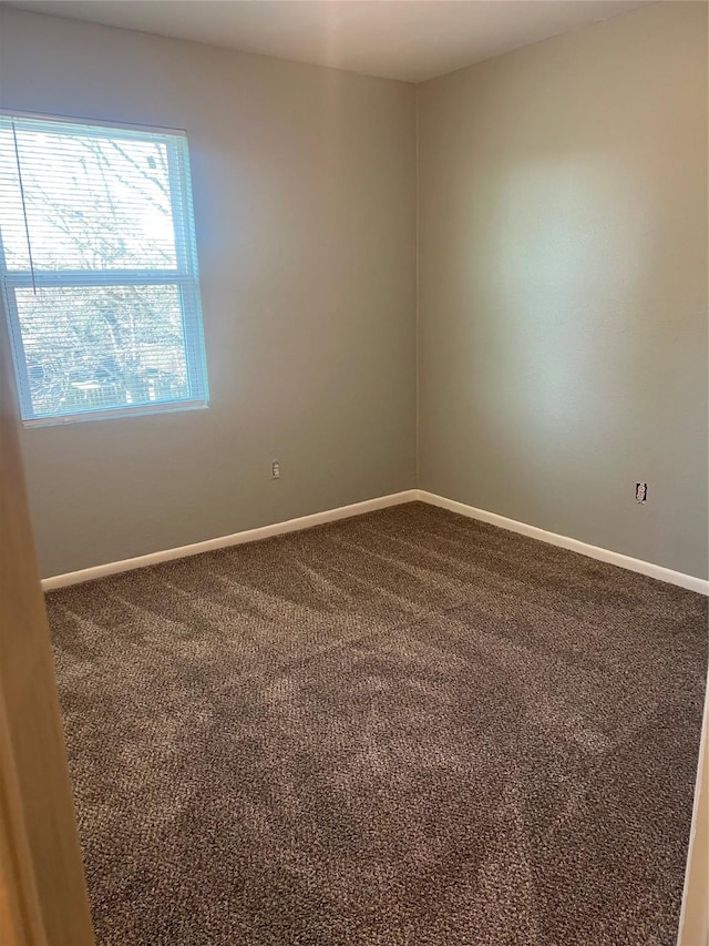 empty room with carpet and baseboards