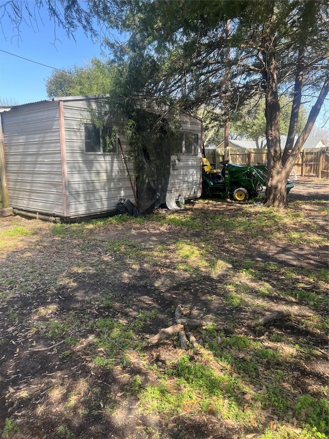 view of yard featuring fence and an outbuilding