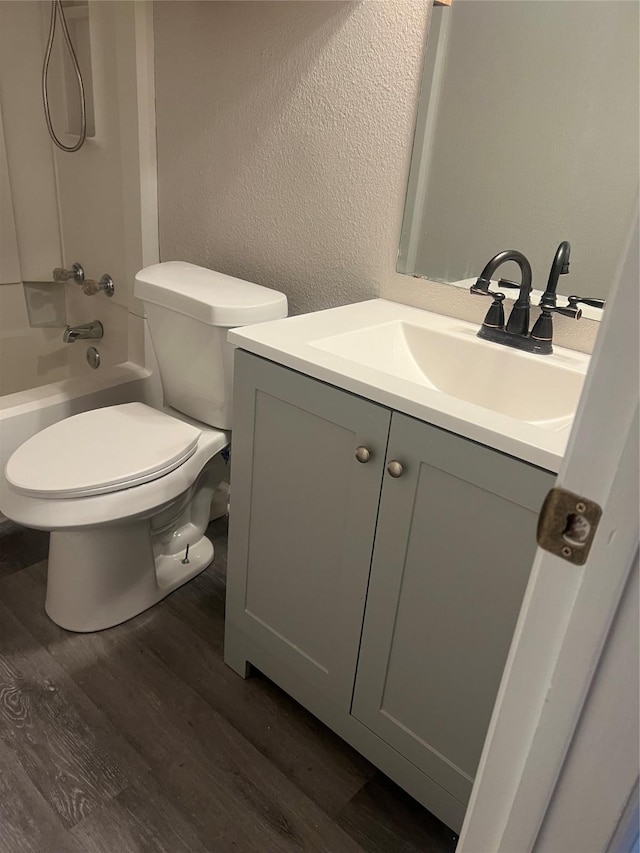 bathroom with shower / bath combination, a textured wall, wood finished floors, and vanity