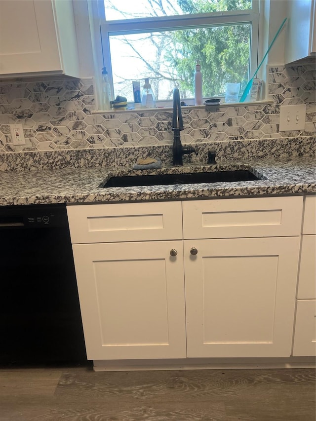 kitchen with white cabinets, dishwasher, backsplash, and a sink