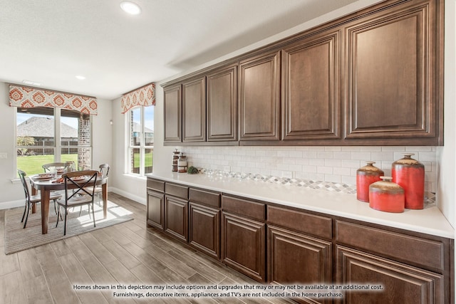 kitchen with recessed lighting, baseboards, light countertops, light wood-type flooring, and decorative backsplash