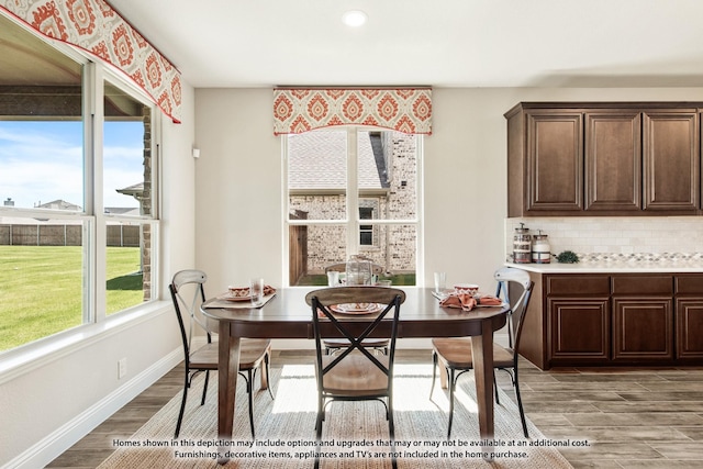 dining area with baseboards and wood finished floors