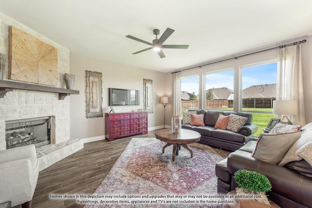 living area featuring a fireplace, wood finished floors, a ceiling fan, and baseboards