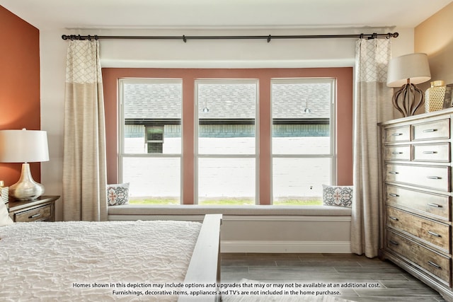 bedroom featuring multiple windows, baseboards, and wood finish floors