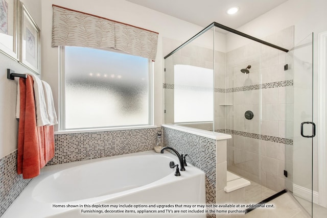 bathroom featuring a shower stall and a bath