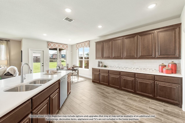 kitchen featuring tasteful backsplash, light countertops, a sink, and stainless steel dishwasher