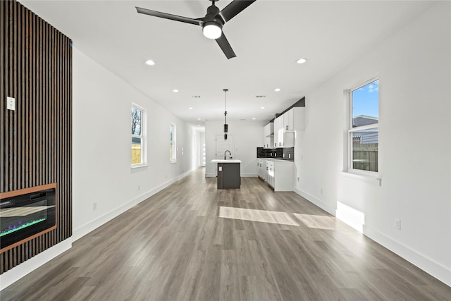 unfurnished living room featuring recessed lighting, plenty of natural light, and wood finished floors