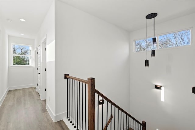 hall with recessed lighting, baseboards, an upstairs landing, and wood finished floors