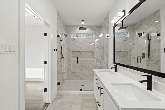 full bathroom with marble finish floor, double vanity, a sink, and a marble finish shower