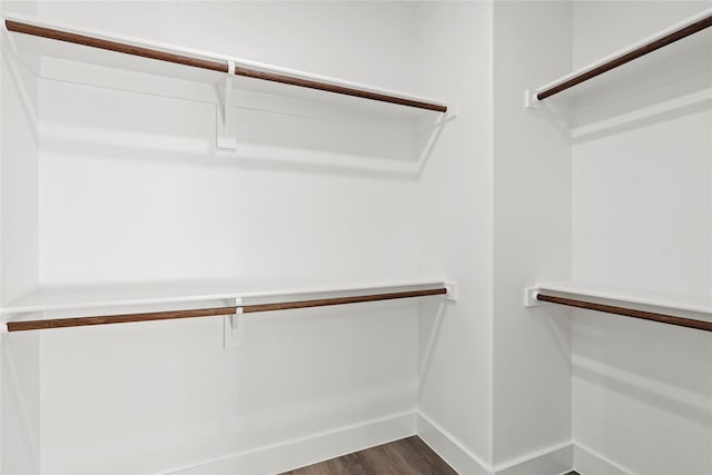 spacious closet with dark wood-style floors