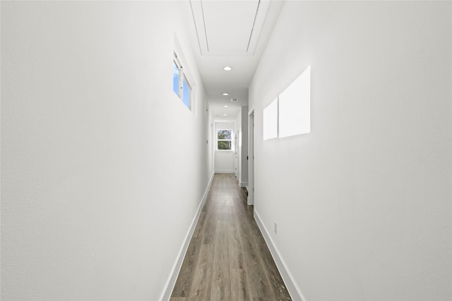 hallway featuring recessed lighting, wood finished floors, attic access, and baseboards