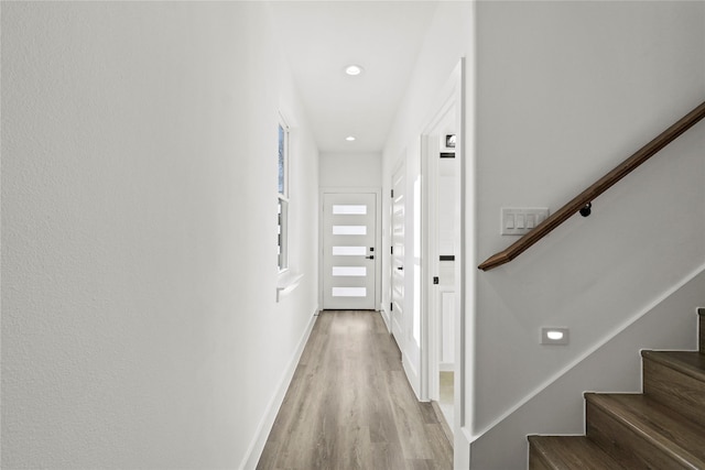 corridor with stairway, recessed lighting, light wood-style flooring, and baseboards