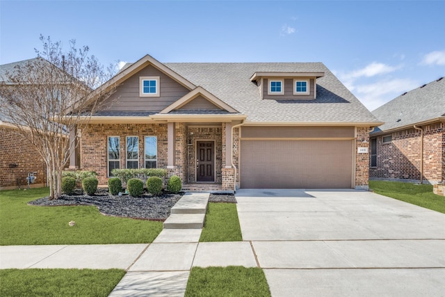 craftsman inspired home featuring a shingled roof, a front lawn, concrete driveway, and brick siding