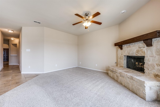 living room featuring baseboards, visible vents, a ceiling fan, light colored carpet, and a fireplace