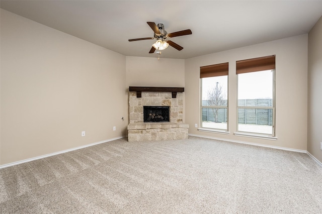 unfurnished living room featuring ceiling fan, a fireplace, baseboards, and carpet flooring