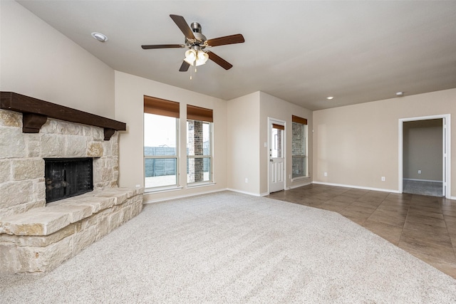 unfurnished living room featuring ceiling fan, a fireplace, baseboards, and tile patterned floors