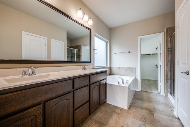 full bathroom with a bath, a shower stall, double vanity, and a sink