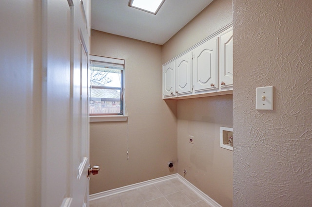 clothes washing area with light tile patterned floors, baseboards, hookup for an electric dryer, cabinet space, and washer hookup