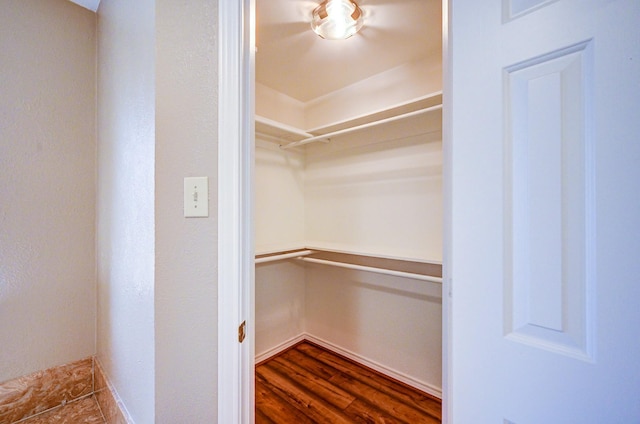 spacious closet with dark wood-style flooring