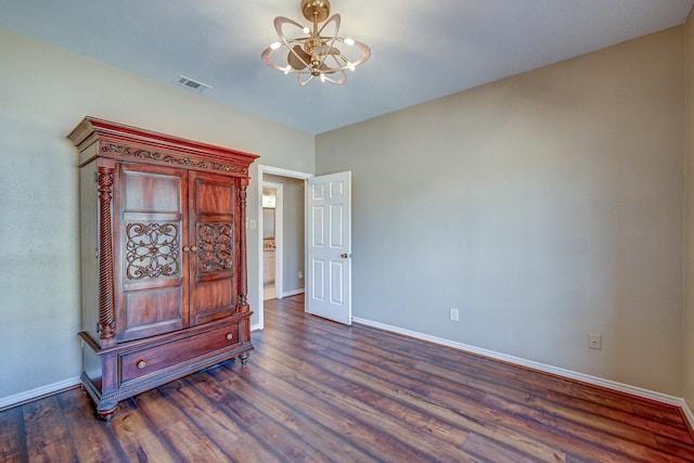 bedroom with a chandelier, visible vents, baseboards, and wood finished floors