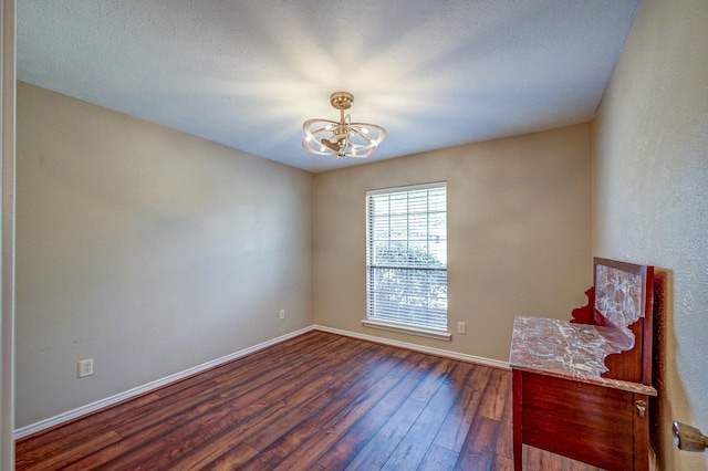 interior space featuring baseboards, wood-type flooring, and a chandelier