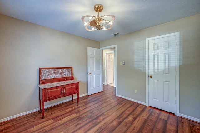 bedroom featuring visible vents, dark wood-style floors, baseboards, and a chandelier