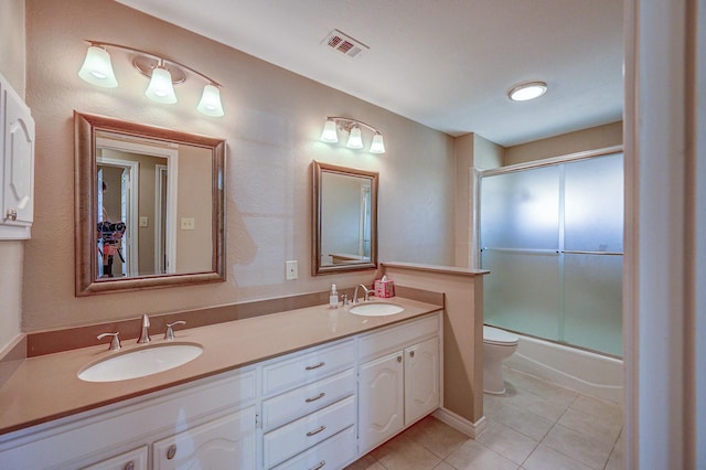 bathroom with a sink, visible vents, double vanity, and tile patterned floors