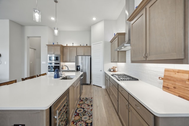 kitchen featuring beverage cooler, decorative backsplash, wall chimney exhaust hood, stainless steel appliances, and a sink