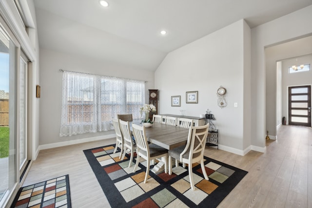 dining room featuring a wealth of natural light, lofted ceiling, and light wood finished floors