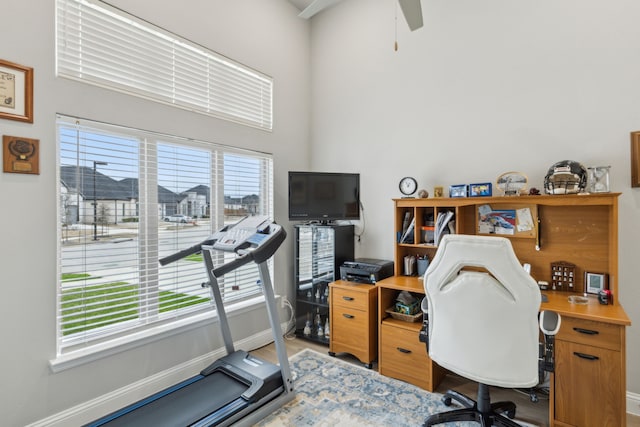 office space featuring ceiling fan, light wood-style flooring, and baseboards