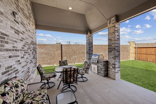 view of patio featuring a grill, outdoor dining area, exterior kitchen, and a fenced backyard